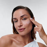 Woman applying Alastin Restorative Skin Complex serum on her face, showcasing its anti-aging benefits.