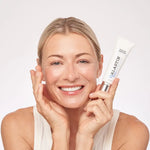 Alastin Ultra Light Moisturizer in hand, showcasing hydration and calm skin with a radiant smile.