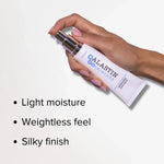 A hand holding Alastin Ultra Light Moisturizer, showcasing its weightless feel and silky finish.