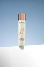 Hydri-C Vitamin C Moisturizer bottle on a white surface against a light blue background.