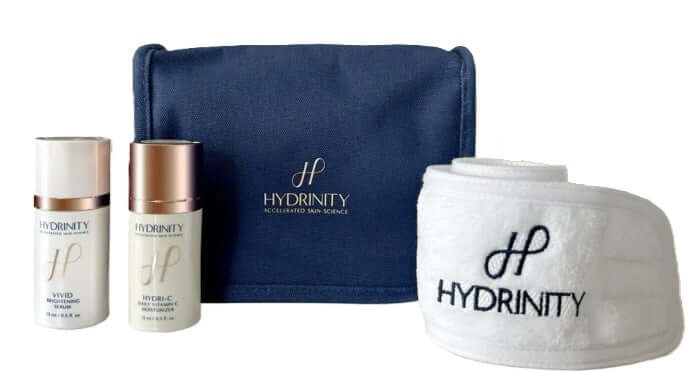 Hydrinity Brightening Set including Vivid Brightening Serum, Hydri-C Daily Vitamin C Moisturizer, headband, and travel bag.