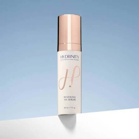 Hydrinity Renewing HA Serum bottle against a blue background, ideal for replenishing hydration and smoothing skin texture.