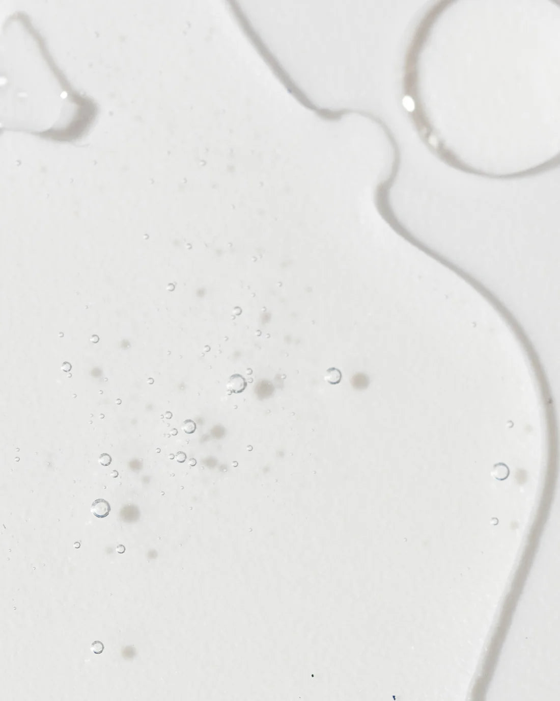 Close-up of Vivier Radiance Serum, showcasing its lightweight, smooth texture with shimmering droplets.
